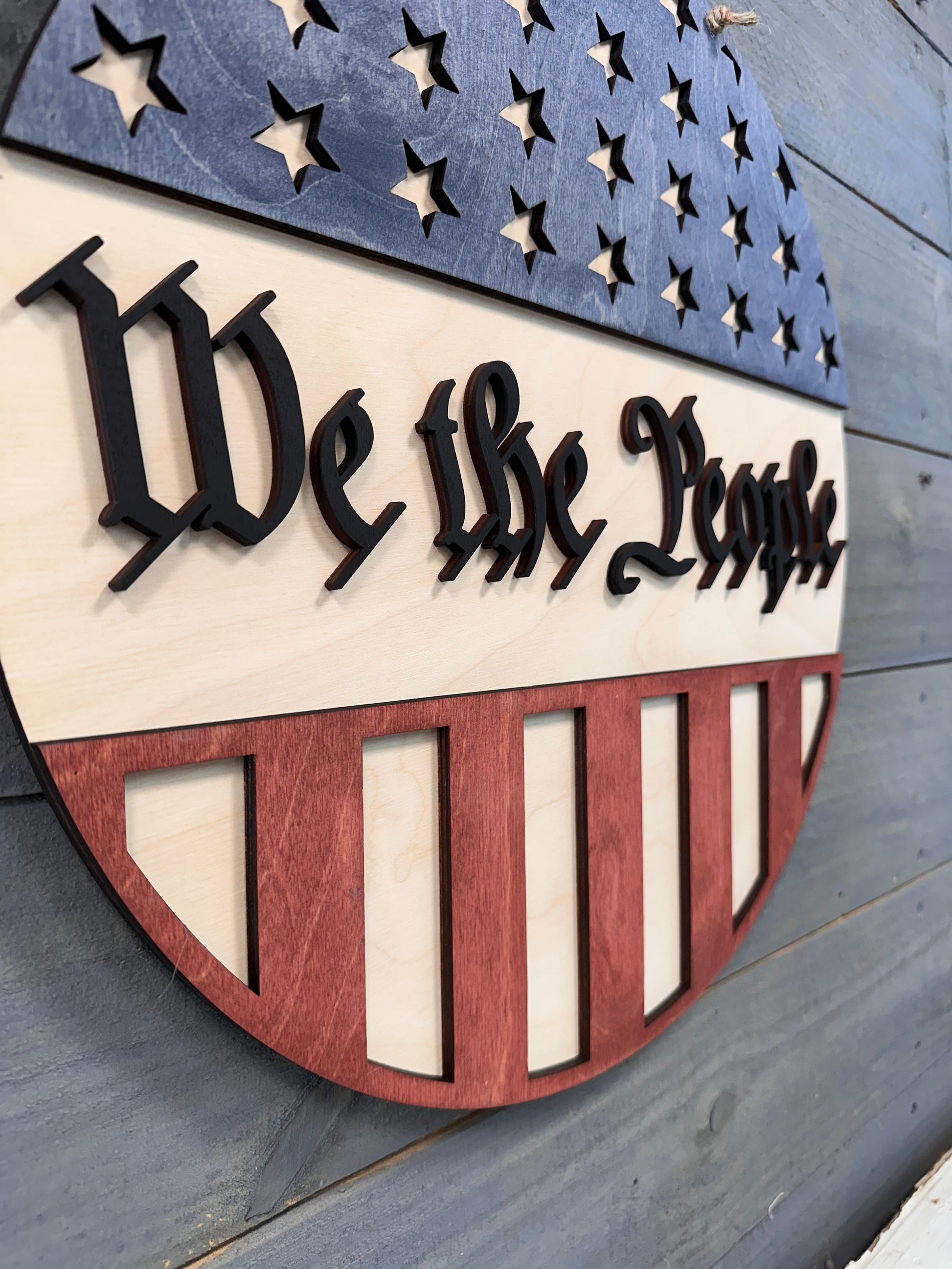 Wooden wall art with American flag design and text on a wooden surface