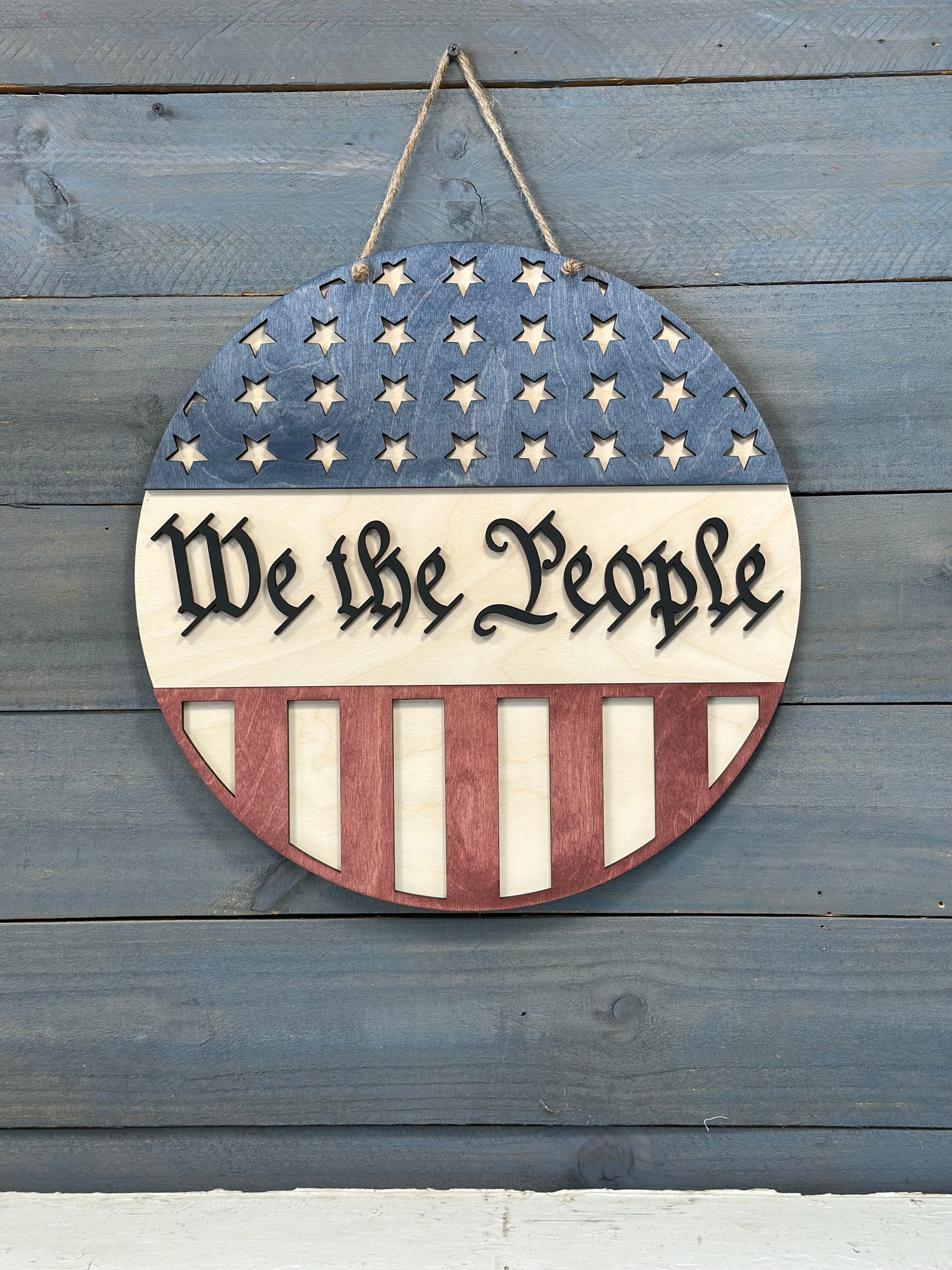 Decorative sign with American flag design and 'Make America Great Again' text on a wooden background.
