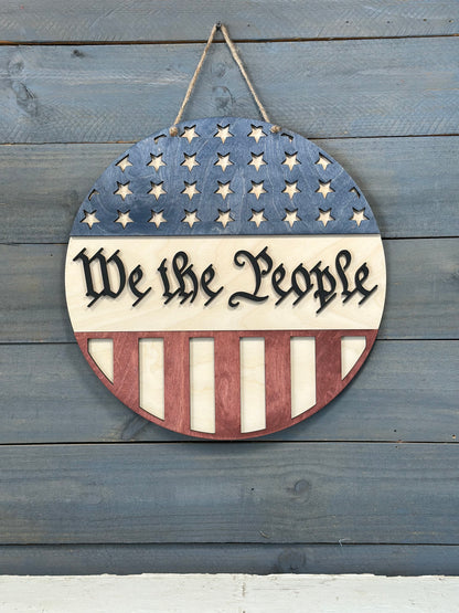 Decorative sign with American flag design and 'Make America Great Again' text on a wooden background.